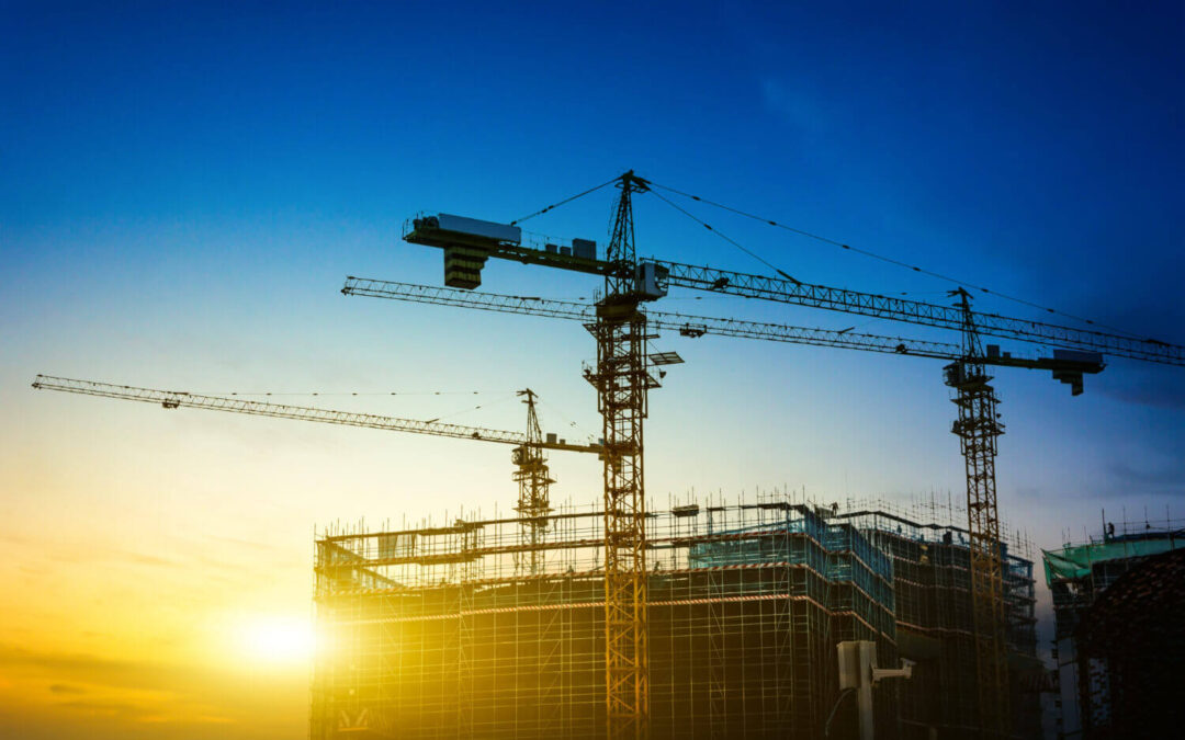 Obras de construcción con grúas en la Costa Blanca al amanecer